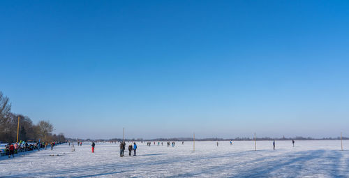 Scenic view of snow covered field against clear blue sky