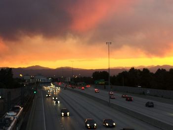 High angle view of cars on street against sky during sunset