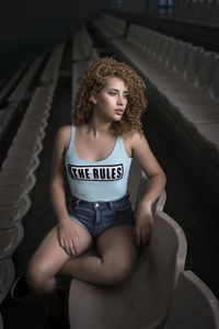 Portrait of young woman with curly hair sitting in a stadium