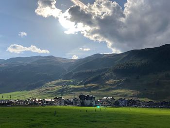 Scenic view of townscape by mountains against sky