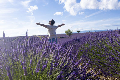 Low angle view of flowering plants on field against sky