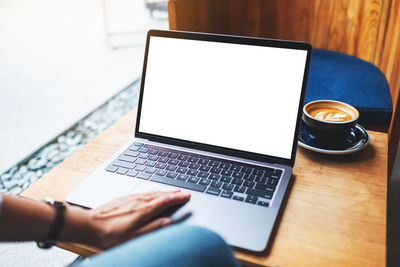 Cropped hands using laptop on table