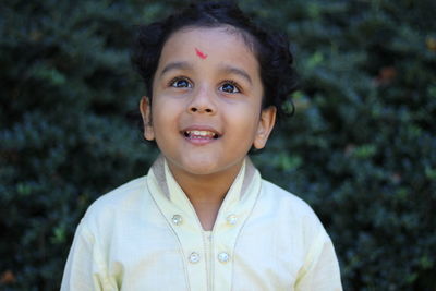 Smiling boy looking away while standing outdoors