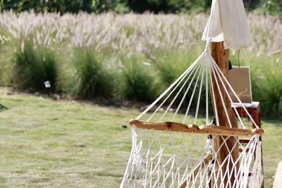 Close-up of hammock hanging on field against trees