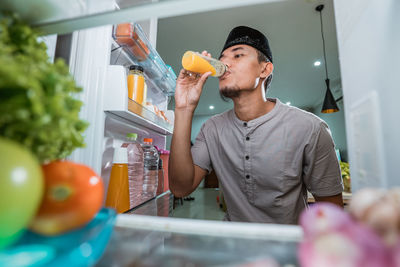 Young man looking away while standing on cutting board