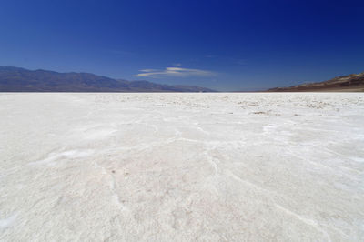 Scenic view of desert against blue sky