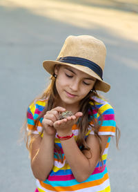 Portrait of smiling girl blowing bubbles while standing outdoors
