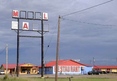 Houses by building against sky