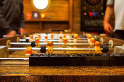 Midsection of friends playing foosball