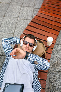 Midsection of man using mobile phone while sitting outdoors