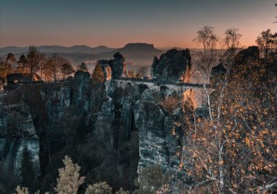 Panoramic view of rocks on landscape against sky during sunset