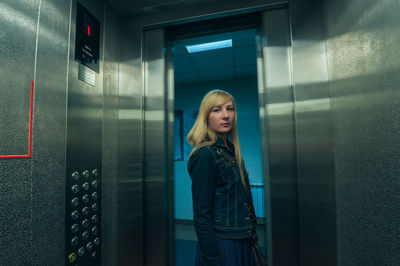 Portrait of young woman standing in elevator
