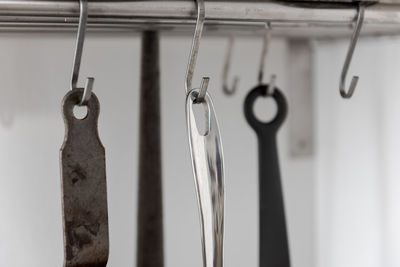 Close-up of clothespins hanging on rope against wall