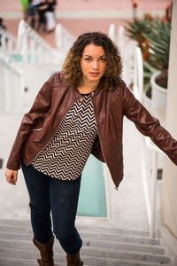 High angle portrait of young woman standing on staircase