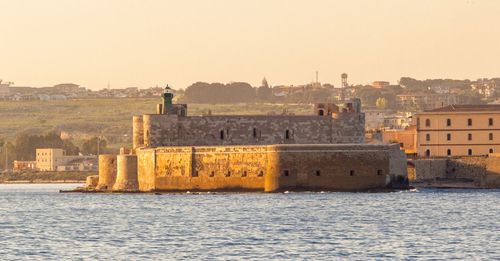 Historic castello maniace in sea against sky