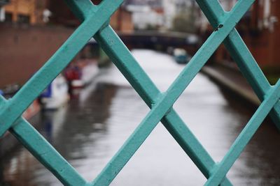 Close-up of metal railing against river