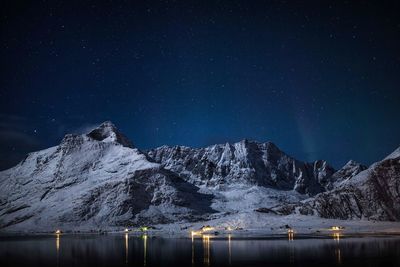 Scenic view of snowcapped mountains against sky at night