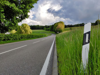 Road amidst green landscape against sky