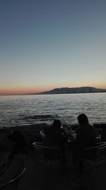 Silhouette of woman in sea at sunset