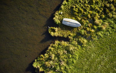 Solitary white wooden boat lying on river beach