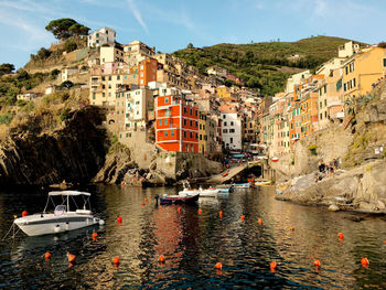 Buildings by sea against mountains in city