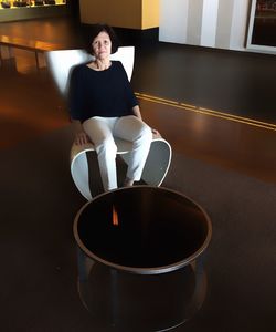 Portrait of senior woman sitting on chair at home