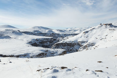 Scenic view of snow covered mountains against sky