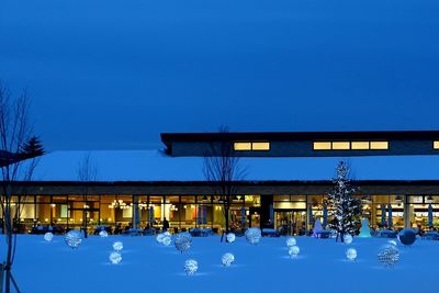 Illuminated built structure against blue sky at night