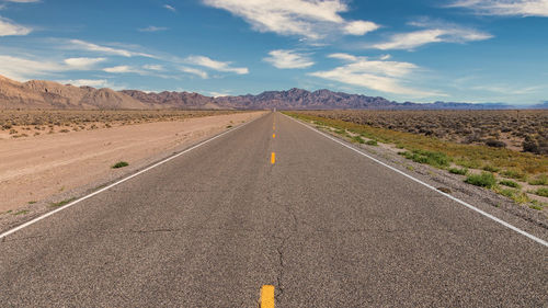 Road passing through landscape against sky