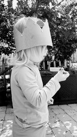 Rear view of woman with umbrella against trees