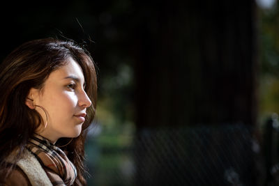 Portrait of a young woman looking away outdoors