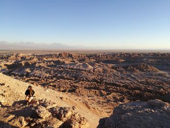 High angle view of woman sitting at mirador de kari - piedra del coyote against sky