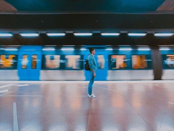 Blurred motion of man standing at subway station