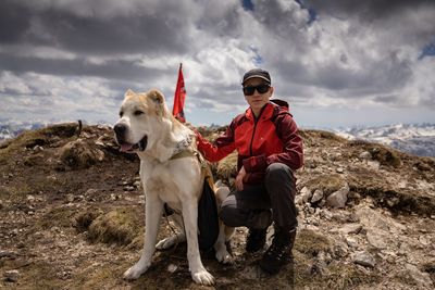 Low angle view of dog standing on rock against sky