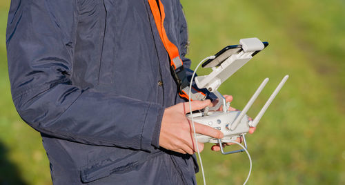 Midsection of man with drone on field