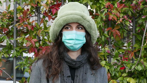 Portrait of young woman wearing mask outdoors