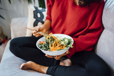 Brunette woman eating a healthy green salad.