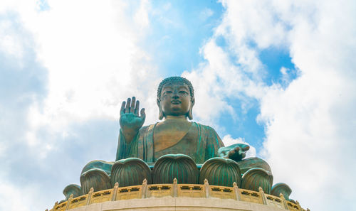 Low angle view of buddha statue against sky