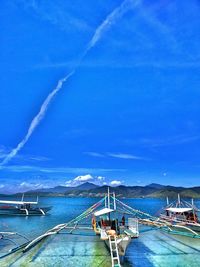 Boats in sea against blue sky