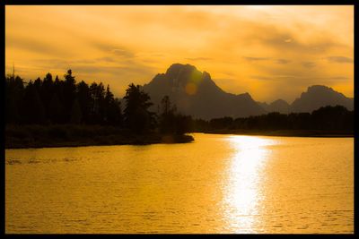 Scenic view of lake against orange sky