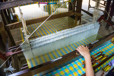 High angle view of cropped hand working at textile industry