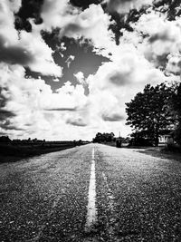 Surface level of empty road against cloudy sky