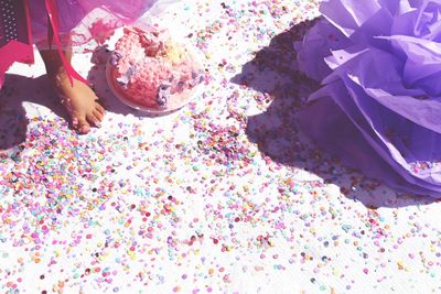 Low section of girl standing by messy birthday cake on floor