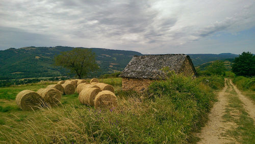 Hay bales on field against sky