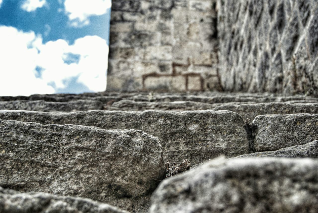 selective focus, built structure, architecture, building exterior, wall - building feature, stone wall, focus on background, sky, day, surface level, tree, house, field, focus on foreground, weathered, outdoors, wall, no people, old, nature