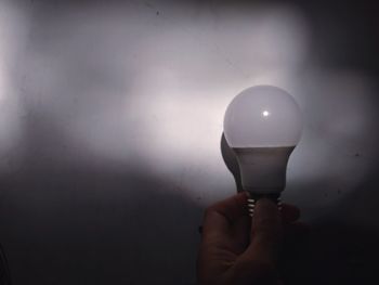 Close-up of hand holding light bulb