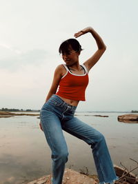 Full length of woman standing at beach against sky