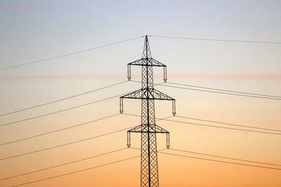 Low angle view of electricity pylon against sky