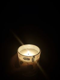 Close-up of illuminated lamp over black background