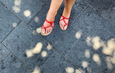 Low section of woman standing on footpath